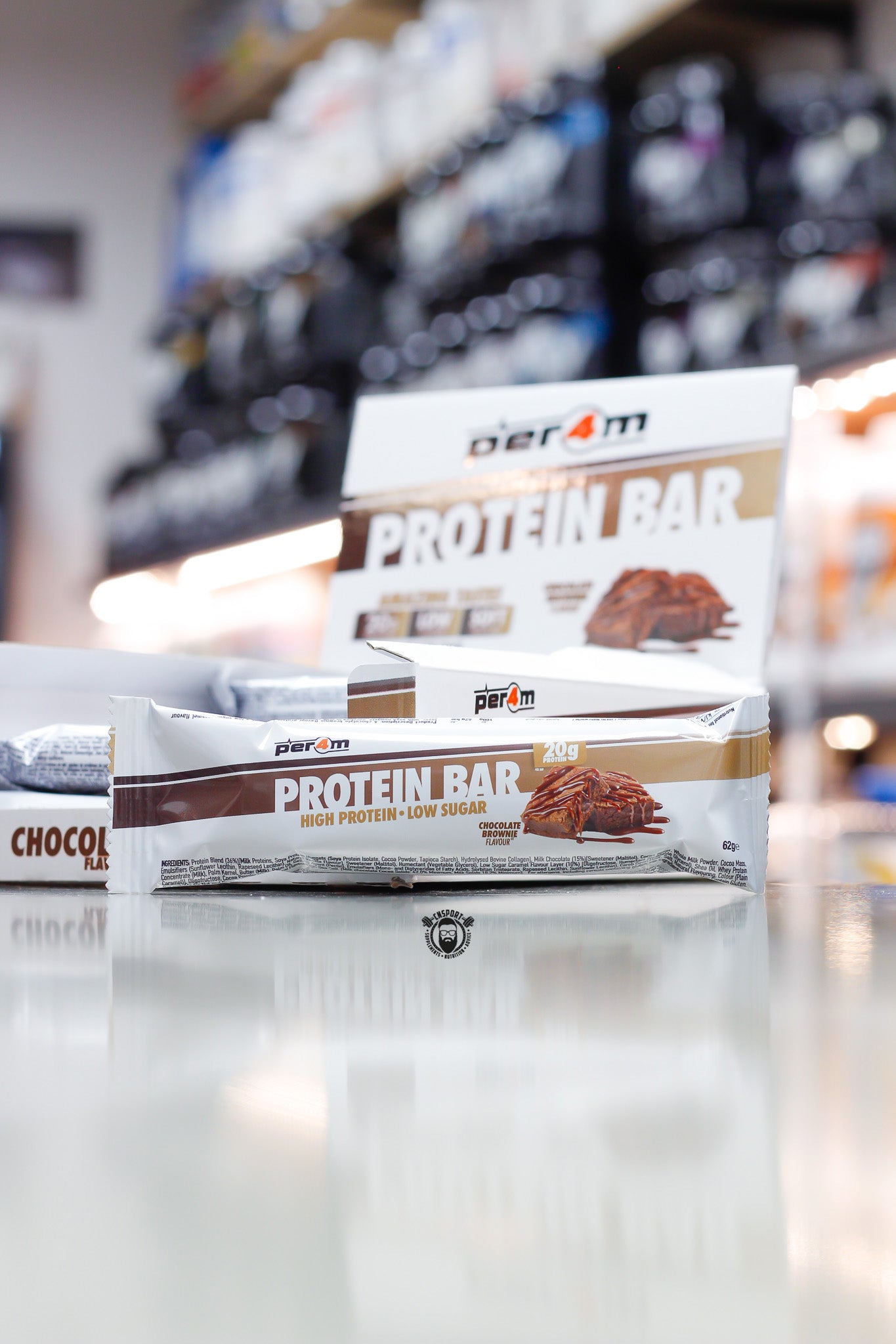 Per4m Protein Bar, Chocolate Brownie flavour (20g protein), high protein low sugar bar displayed in front of open retail box in supplement store.