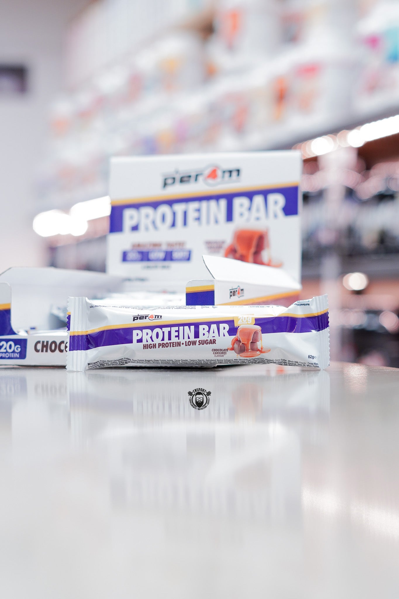 Per4m Protein Bar, Chocolate Caramel flavour (20g protein), high protein low sugar bar displayed in front of open retail box in supplement store.