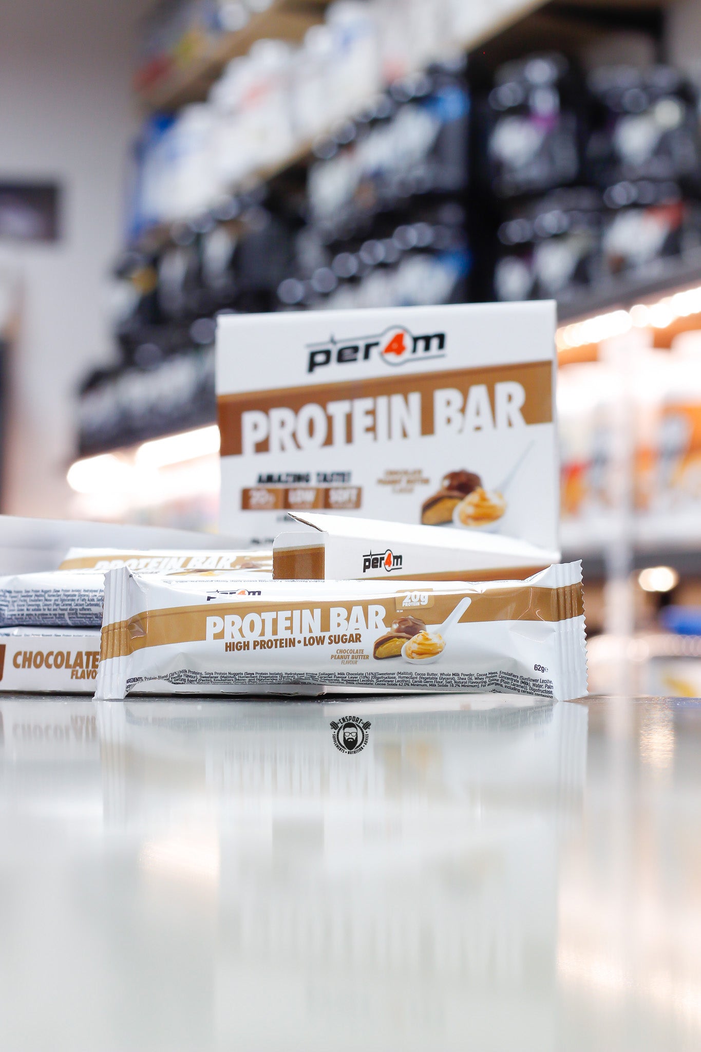 Per4m Protein Bar, Chocolate Peanut Butter flavour (20g protein), high protein low sugar bar displayed in front of open retail box in supplement store.