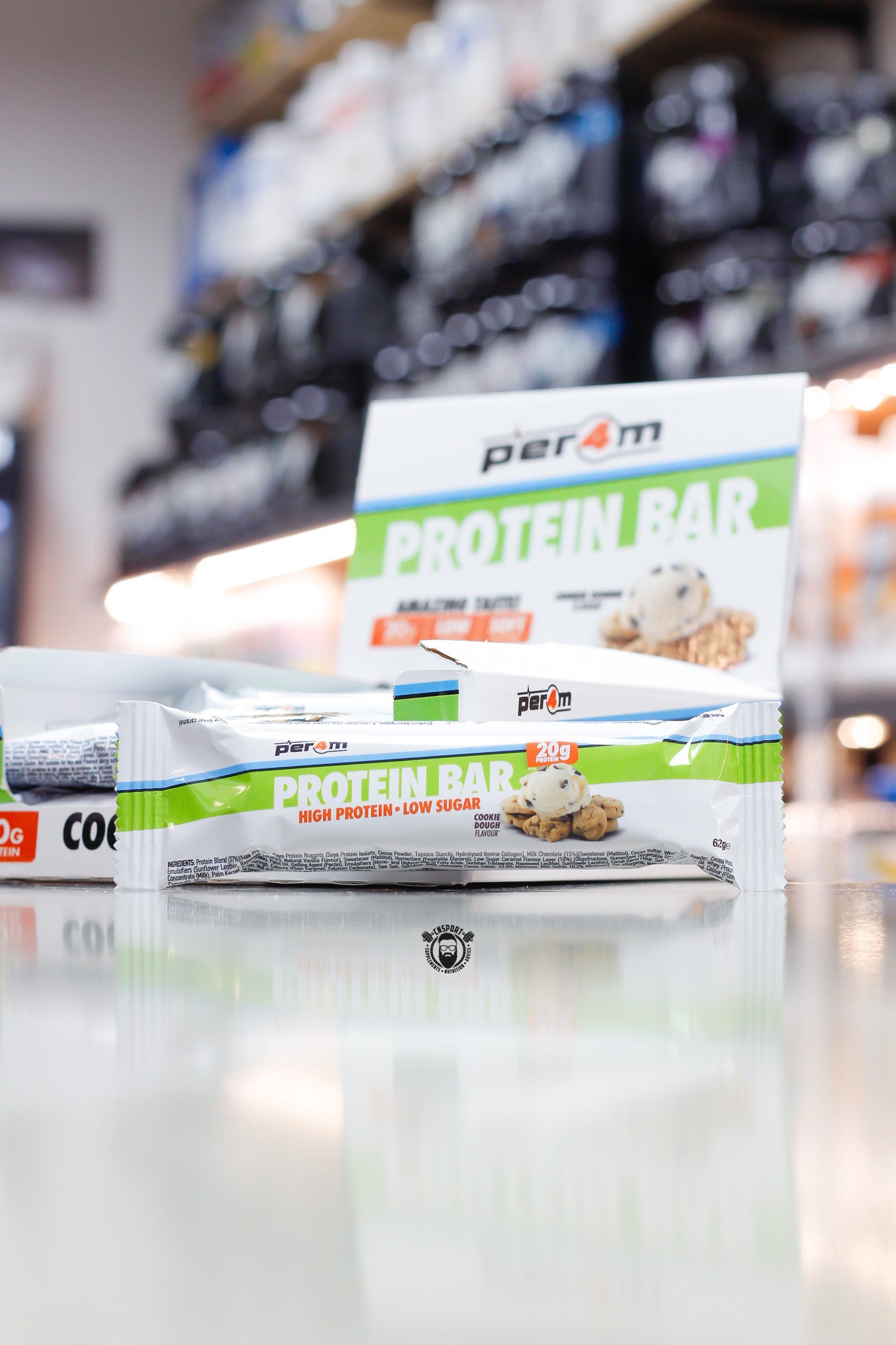 Per4m Protein Bar, Cookie Dough flavour (20g protein), high protein low sugar bar displayed in front of open retail box in supplement store.