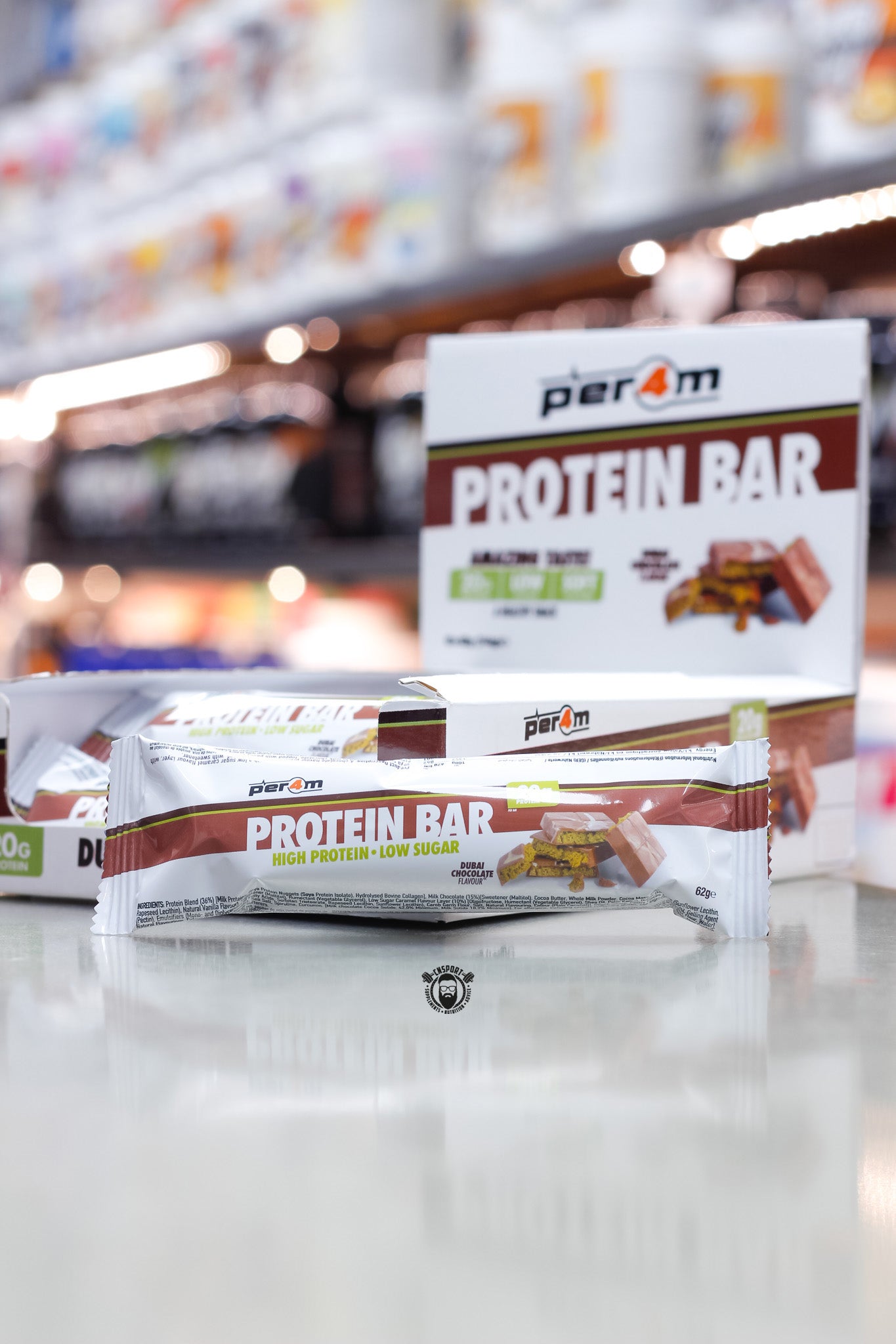 Per4m Protein Bar, Dubai Chocolate flavour (20g protein), high protein low sugar bar displayed in front of open retail box in supplement store.