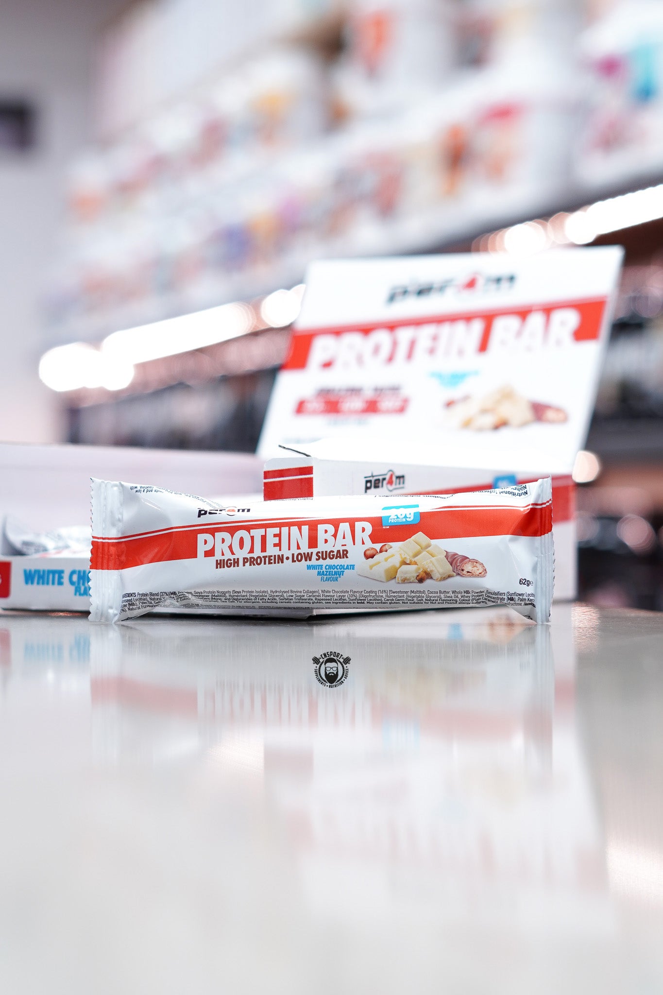 Per4m Protein Bar, White Chocolate Hazelnut flavour (20g protein), high protein low sugar bar displayed in front of open retail box in supplement store.