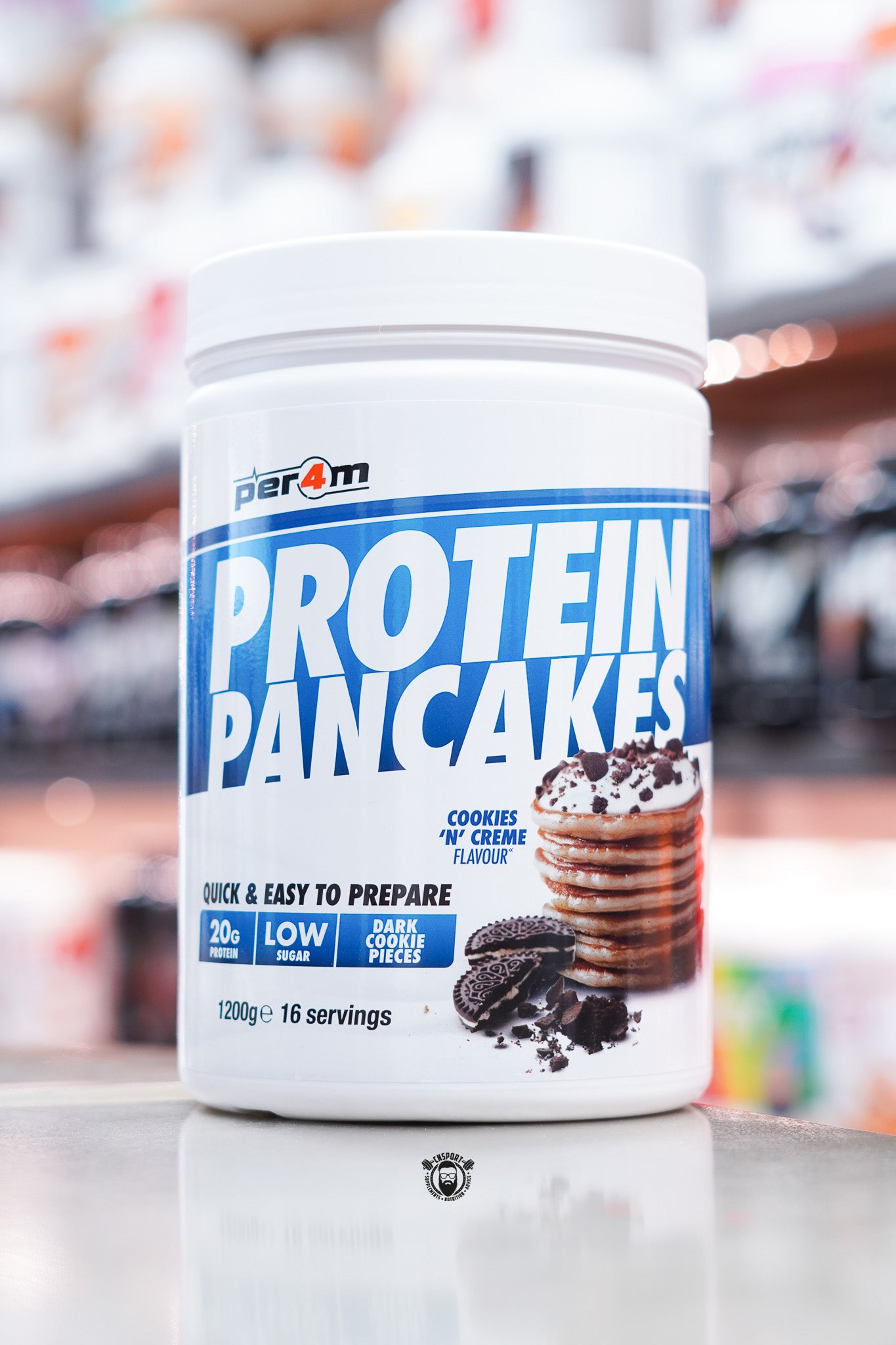 White tub of Per4m Protein Pancakes, Cookies ’N’ Creme flavour, featuring pancakes topped with cookie crumbs and Oreo-style cookies on the label.