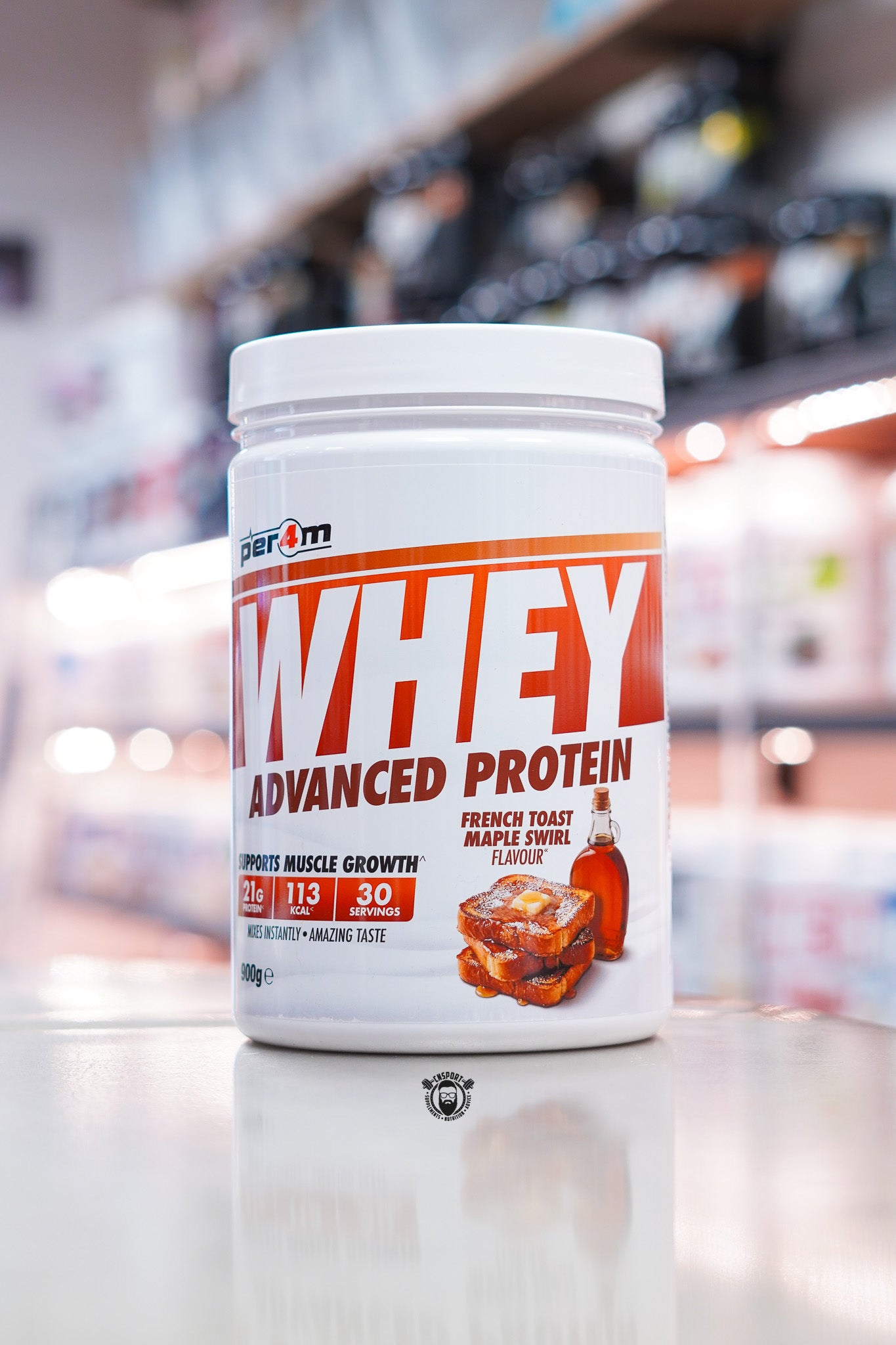 Per4m Whey Advanced Protein French Toast Maple Swirl 900g protein powder tub with 21g protein per serving and 30 servings, displayed on a supplement store counter with French toast and maple syrup flavour imagery on the front label.