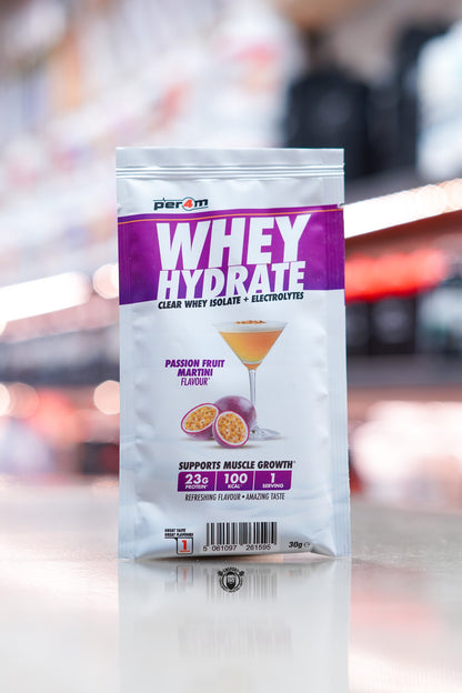 Per4m Whey Hydrate 30g sample sachet, Passion Fruit Martini flavour, clear whey isolate with electrolytes, displayed on counter in supplement store.