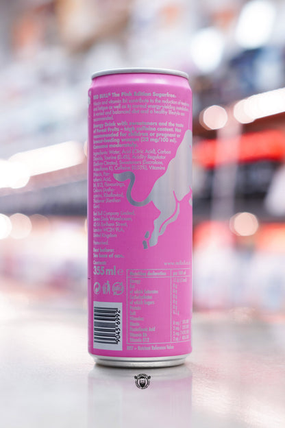 Side view of Red Bull The Pink Edition Sugarfree 355ml can showing product information and pink background with metallic bull silhouette.