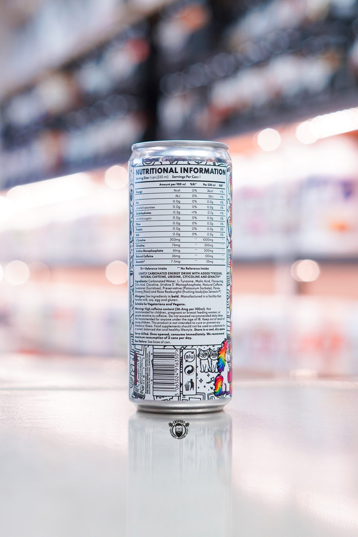 Back panel of Strom FocusMax 330ml energy drink can showing nutritional information, ingredients and barcode on retail counter with blurred supplement store background
