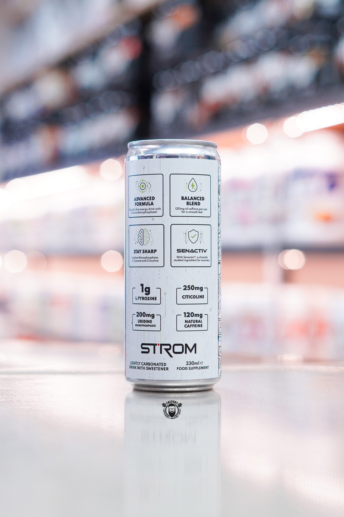 Side panel of Strom FocusMax 330ml energy drink can showing formula highlights including tyrosine, citicoline, uridine monophosphate and natural caffeine on retail counter with blurred supplement store background