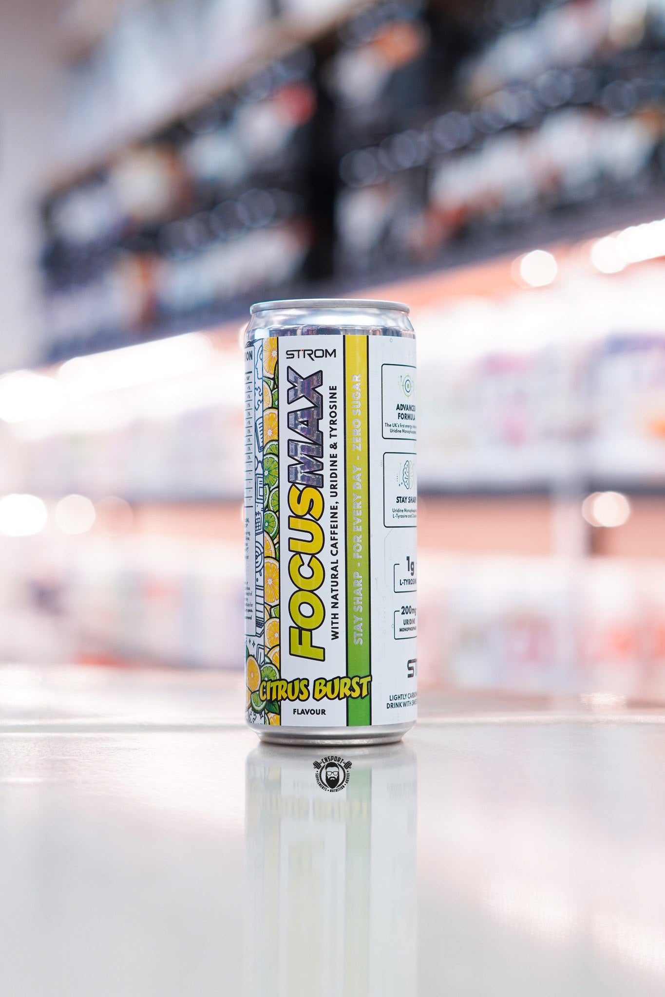 Strom FocusMax Citrus Burst zero sugar energy drink can with natural caffeine, uridine and tyrosine on retail counter with blurred supplement store background