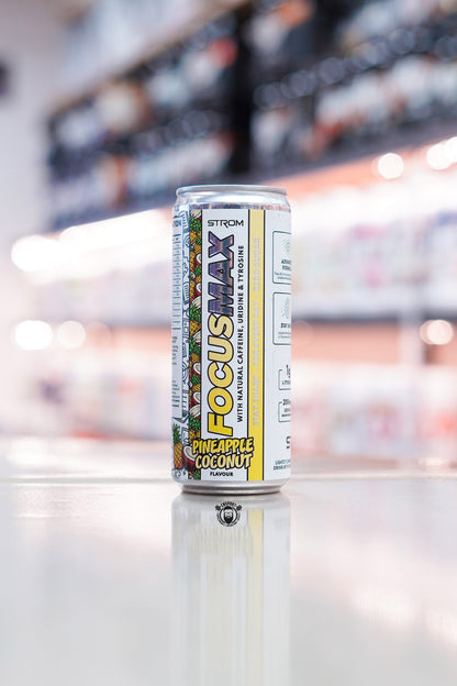 Strom FocusMax Pineapple Coconut zero sugar energy drink can with natural caffeine, uridine and tyrosine on retail counter with blurred supplement store background
