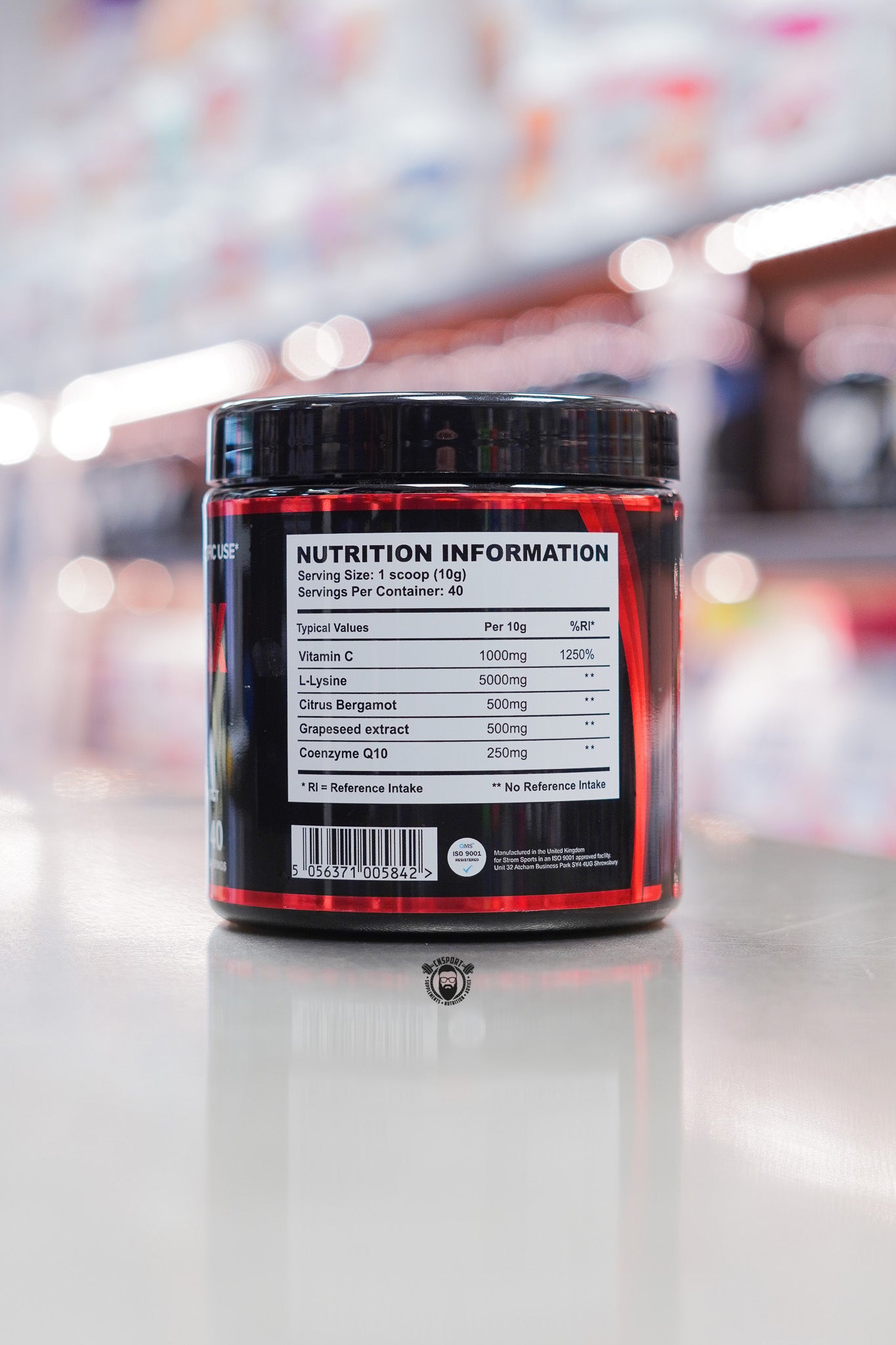 Strom Sports LipidMax Mango flavour supplement tub showing nutrition information panel on a reflective counter