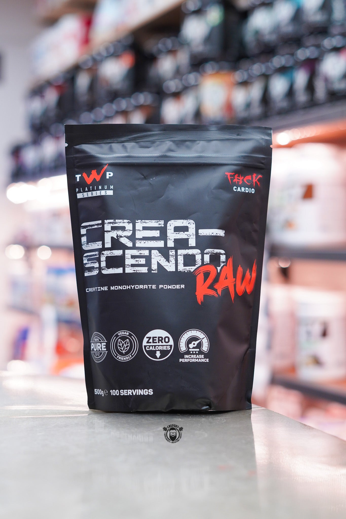 TWP Crea-Scendo RAW creatine monohydrate powder, 500g pouch with 100 servings, displayed on a supplement store counter.