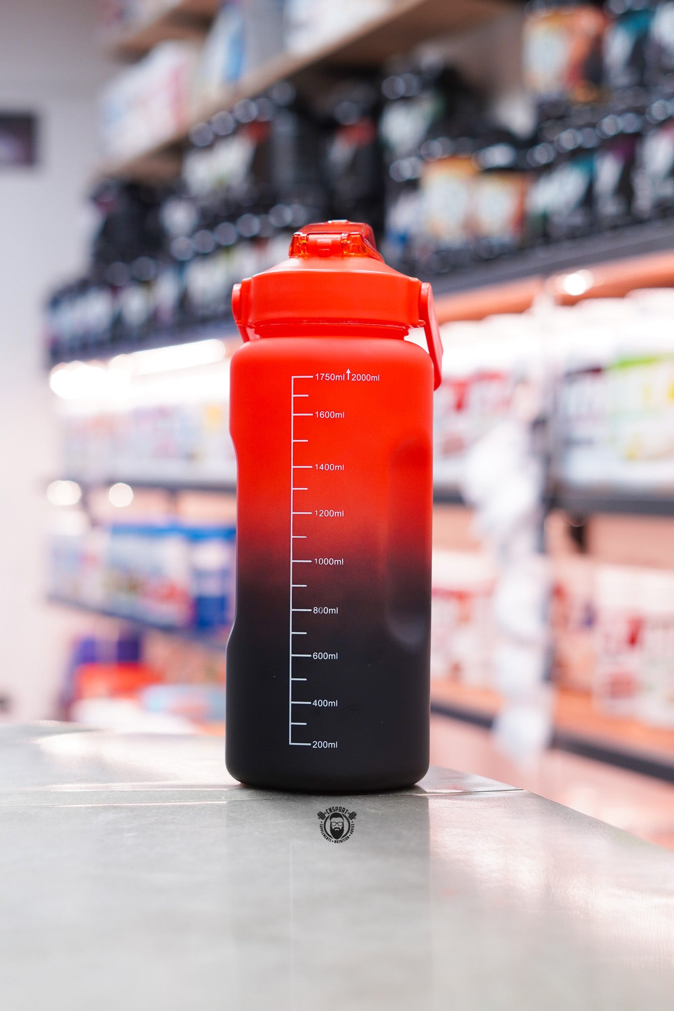 Rear view of the TWP Cardio 2L hydration water bottle showing the printed volume measurement scale from 200ml to 2000ml and carry handle.