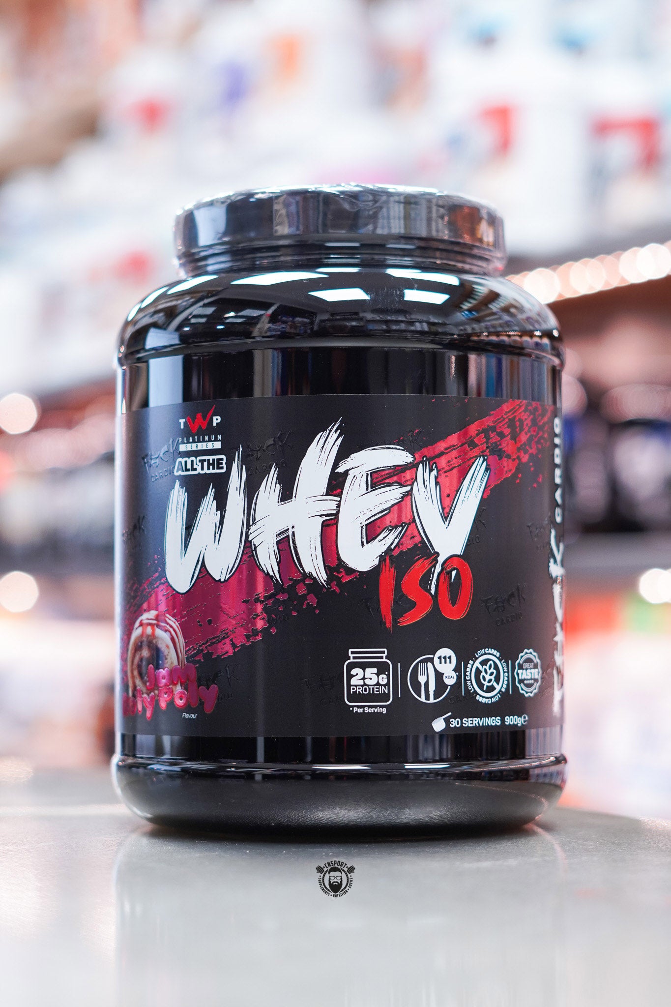 Alternate front-facing angle of TWP All The Whey Iso Jam Roly Poly flavour highlighting red and black packaging with dessert swirl design.