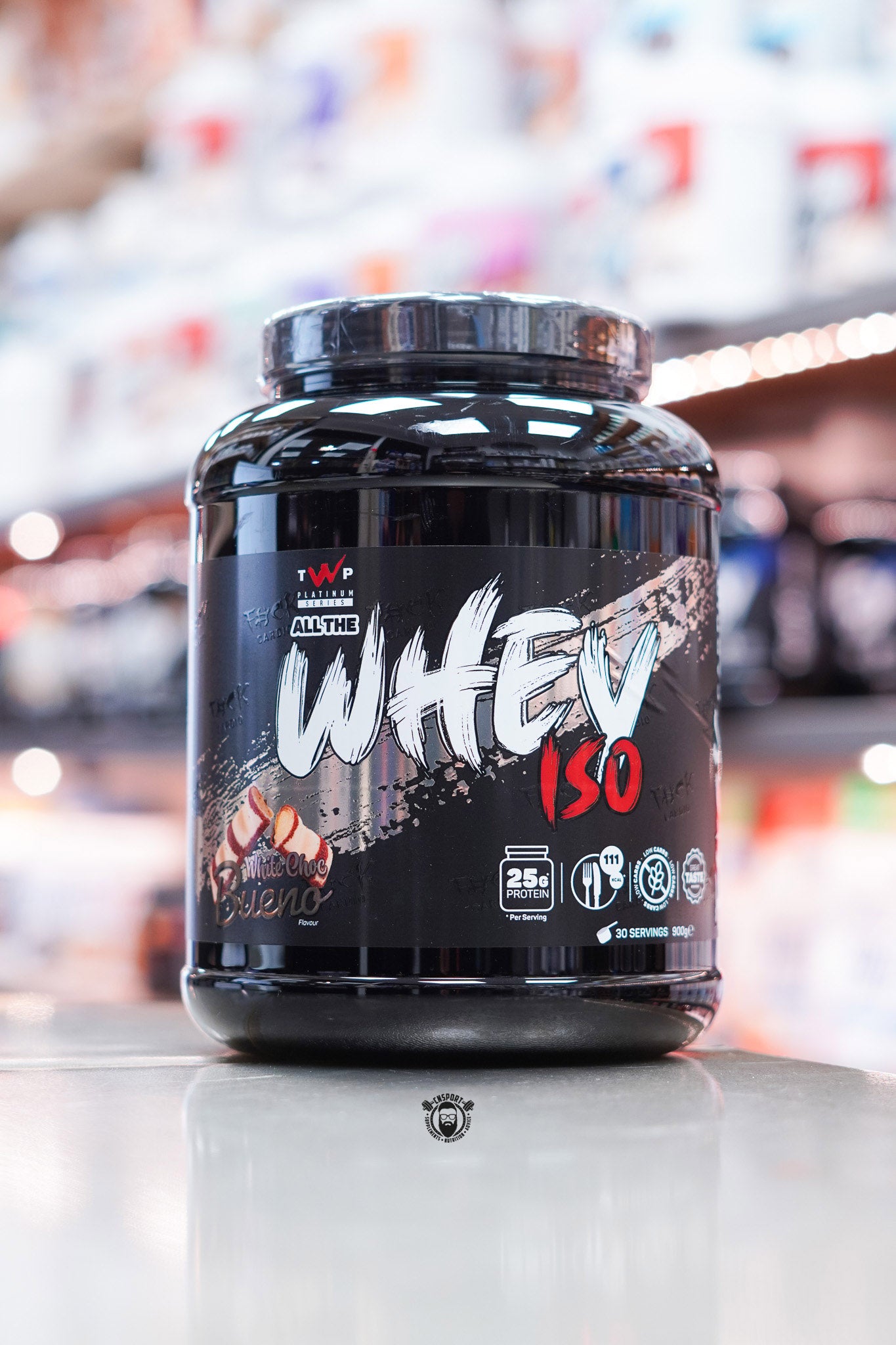 Front-facing image of TWP All The Whey Iso White Choc Bueno flavour with creamy dessert imagery and sleek black packaging.