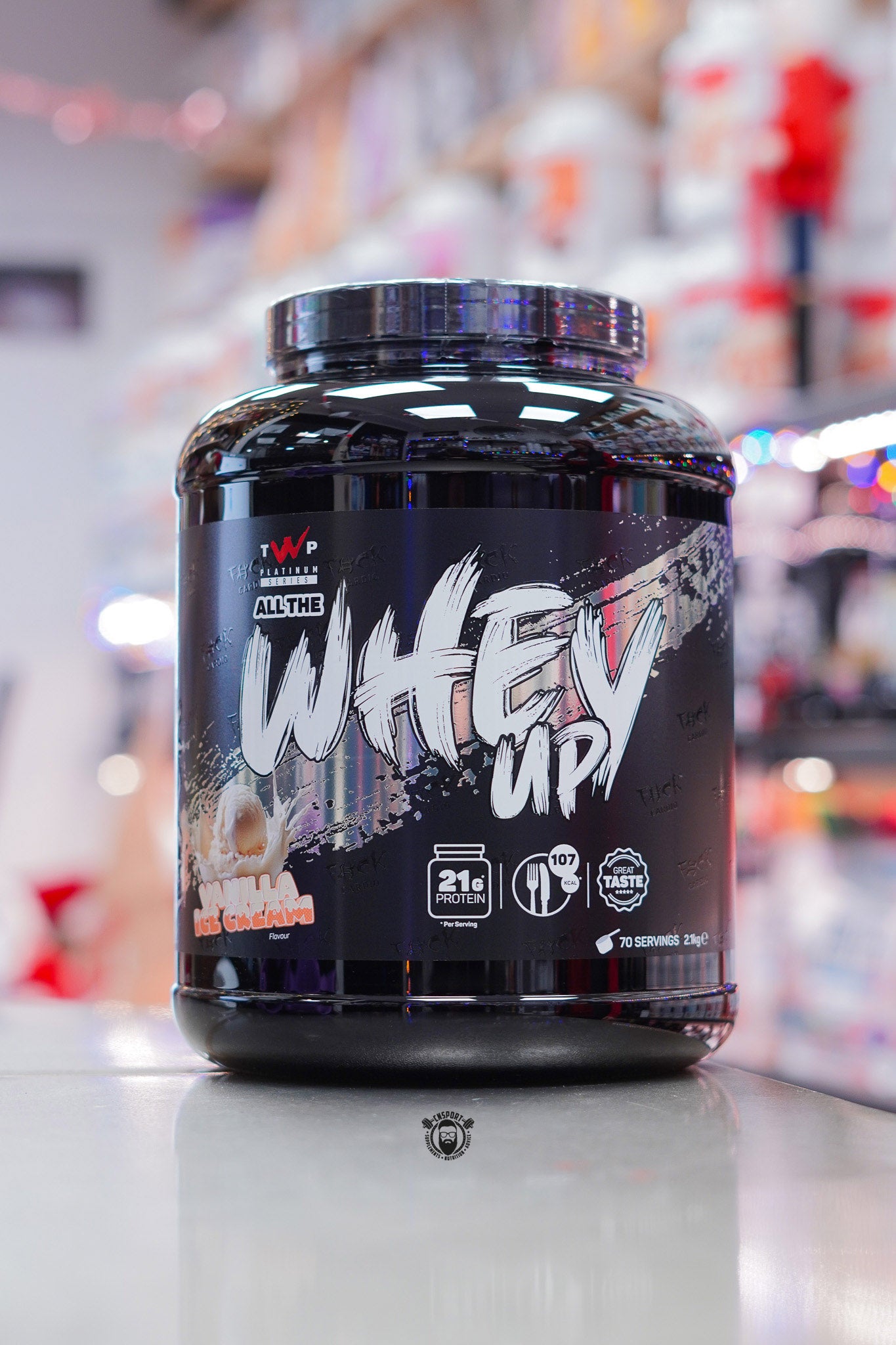 TWP Platinum Series All The Whey Up protein powder in Vanilla Ice Cream flavour, large black tub photographed in a retail supplement store.
