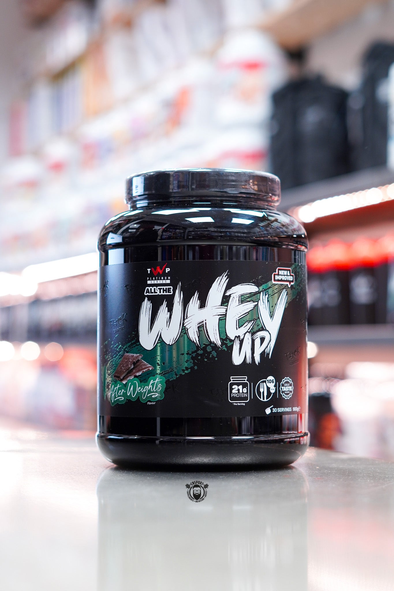 TWP Platinum Series All The Whey Up protein powder, After Weights flavour, 900g black tub with green and white label, displayed on counter in supplement store.