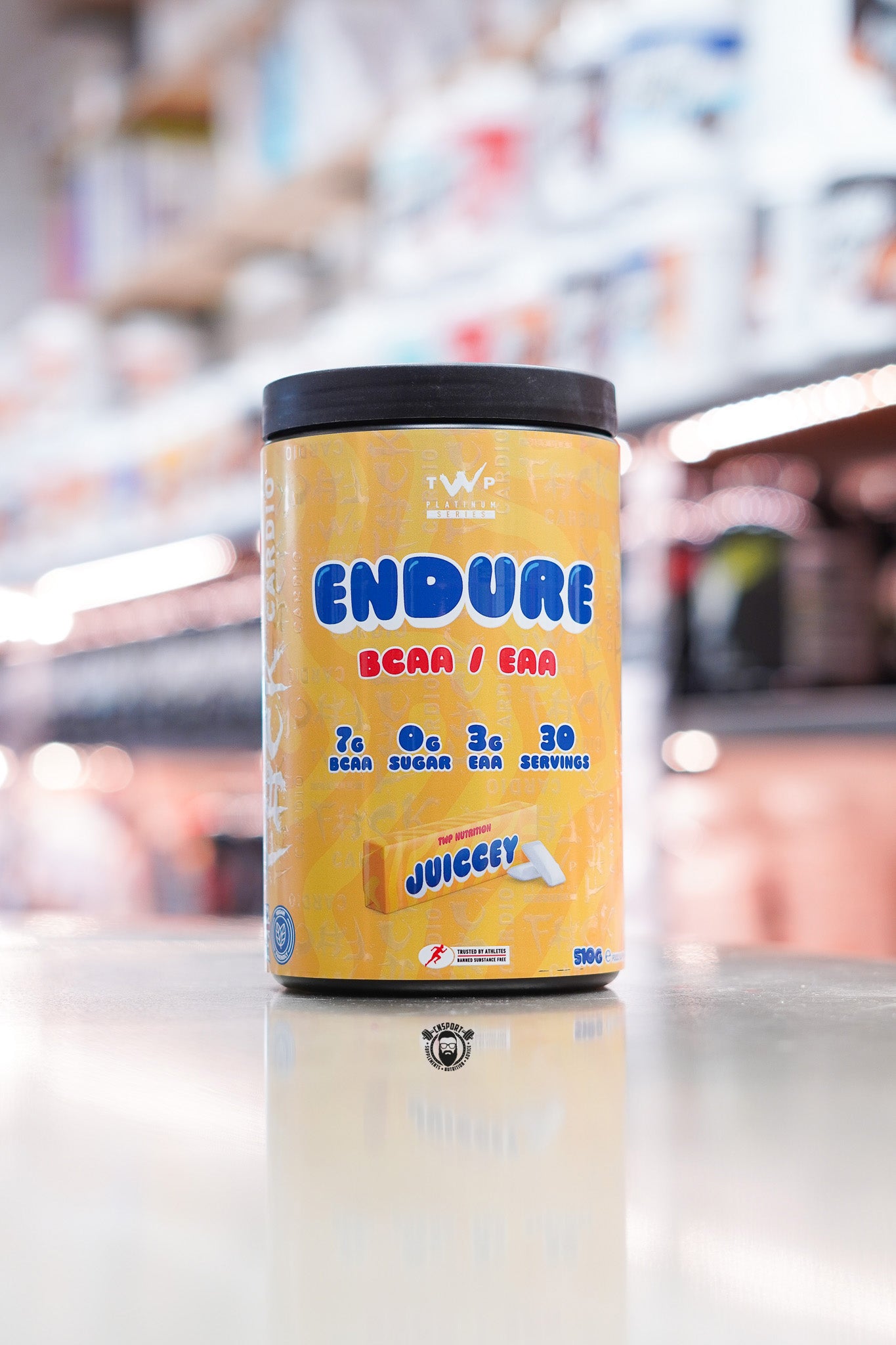 TWP Platinum Series Endure BCAA / EAA supplement, Juiccey flavour, 510g tub, displayed on supplement store counter.